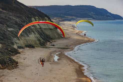 Aerial view of two paramotor pilots flying over natural beach at the Black Sea coast of Istanbul, Turkey. - AAEF21921