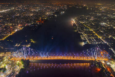 Luftaufnahme des architektonischen Wahrzeichens Howrah-Brücke oder Rabindra Setu über den Hooghly-Fluss bei Nacht in Kolkata, Westbengalen, Indien. - AAEF21973