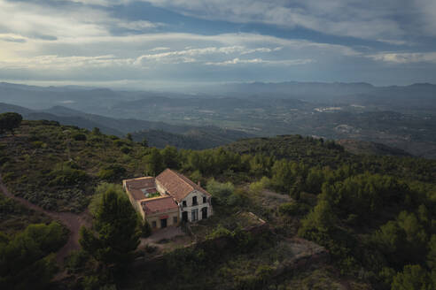 Aerial view of a small house on top of a mountain with cloudy cinematic sky and lighting, Mirador de Garbi, Estivella, Valencia, Spain. - AAEF22082