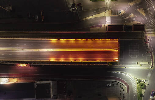 Aerial view of tunnel road at night with worm lights in Grao, Valencia, Spain. - AAEF22108