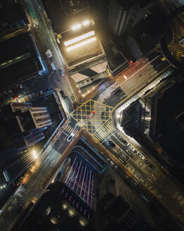 Aerial view of vehicles driving a road intersection at night in Hong Kong downtown. - AAEF22176