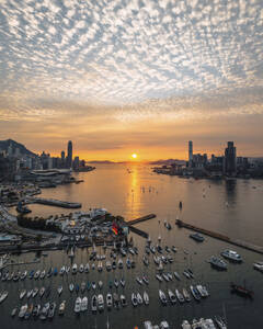 Aerial view of many boats sailing along the bay near the harbour in Hong Kong downtown at sunset. - AAEF22204