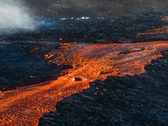 Aerial view of lava flowing from Litli-Hrutur (Little Ram) Volcano during an eruption on Fagradalsfjall volcanic area in southwest Iceland at night, it's a fissure eruption started on the Reykjanes Peninsula, Iceland. - AAEF22237
