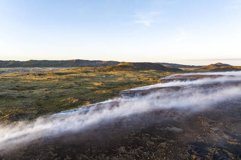Aerial view of the magma flowing and burning grass across the valley from Litli-Hrutur (Little Ram) Volcano during an eruption on Fagradalsfjall volcanic area in southwest Iceland. - AAEF22270