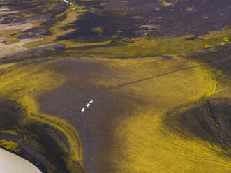 Aerial view of vehicles driving an offroad path along Krokspollur Lake, Hella, Southern Region, Iceland. - AAEF22337