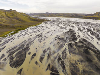 Aerial view of a river estuary crossing the valley with mountain in background Hella, Southern Region, Iceland. - AAEF22346