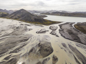 Aerial view of a river estuary crossing the valley with mountain in background Hella, Southern Region, Iceland. - AAEF22347