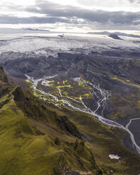Luftaufnahme einer Flussmündung, die das Tal durchquert, mit Bergen im Hintergrund, Kirkjubaejarklaustur, Südregion, Island. - AAEF22362