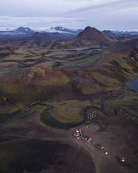 Luftaufnahme von Häusern entlang des Flusses in der Nähe des Alftavatn-Sees in der Dämmerung inmitten der Berge im isländischen Hochland, Hella, Südregion, Island. - AAEF22394