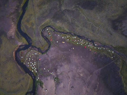 Luftaufnahme von Zelten auf einem Campingplatz entlang des Flusses in der Nähe des Alftavatn-Sees in der Dämmerung, Hella, Südregion, Island. - AAEF22396