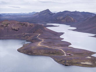 Luftaufnahme des Langisfor-Sees bei Sonnenuntergang, eines malerischen, von Bergen und einem vulkanischen Tal umgebenen Sees, Kirkjubaejarklaustur, Südregion, Island. - AAEF22432