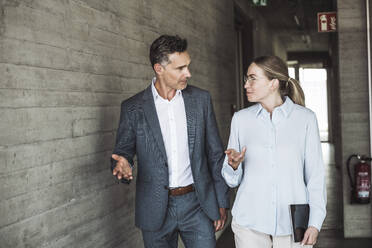 Businessman and businesswoman having discussion in office - UUF30439