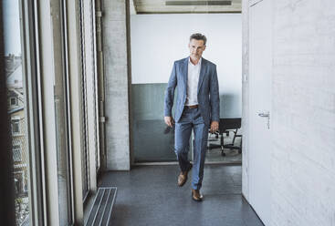 Man in blue pinstripe suit in tailors boutique stock photo