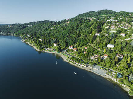 Luftaufnahme einer Straße entlang der Küste mit vertäuten Segelbooten am Lago Maggiore (Lago Maggiore) bei Sonnenaufgang, Novara, Piemont, Italien. - AAEF22497