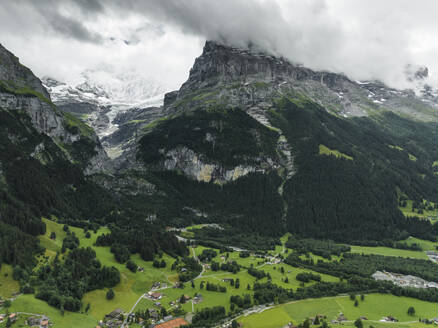 Aerial view of Bernese Alps in Grindelwald town in summertime with clouds, Swiss Alps, Canton of Bern, Switzerland. - AAEF22516