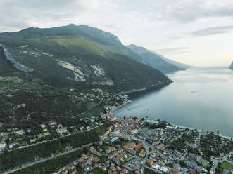 Luftaufnahme von Torbole, einer kleinen Stadt am Gardasee mit dem Fluss Sarca, der das Dorf bei Sonnenuntergang durchquert, Trentino, Italien. - AAEF22570