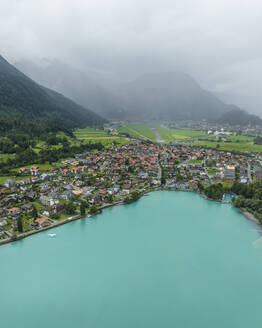 Luftaufnahme von Bonigen, einer kleinen Stadt am Brienzersee, mit Regen und tief hängenden Wolken, Kanton Bern, Schweiz. - AAEF22650