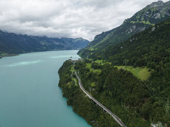 Aerial view of a road following the Brienzersee Lake coastline, Bonigen, Bern, Switzerland. - AAEF22654
