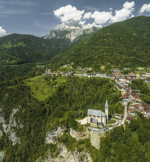 Luftaufnahme der Kirche San Martino in Valle di Cadore, einer kleinen Stadt inmitten von Bergen und dem Berg Antelao im Hintergrund in den Dolomiten in Venetien, Belluno, Italien. - AAEF22761