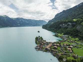 Luftaufnahme von Iseltwald, einer kleinen Stadt am Brienzersee, im Sommer bei Regen und tief hängenden Wolken, Bern, Schweiz. - AAEF22826