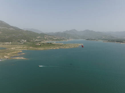 Aerial view of a person doing Parasailing in Khanpur dam, Islamabad Capital Territory, Pakistan. - AAEF22867