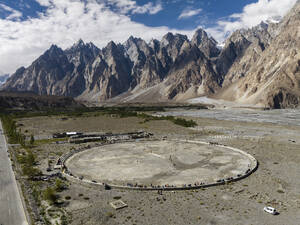 Aerial view of cricket match with Passu Cathedral right in back, Passu, Hunza Valley, Himalayas, Pakistan. - AAEF22875