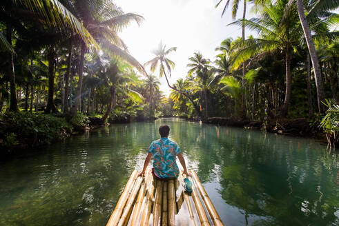 Berühmte, auf Instagram gezeigte, schiefe Palme am Maasin River in Siargao, Philippinen - Menschen, die sich auf einer Kokospalme im Dschungel vergnügen - DMDF04906