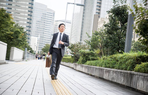 Japanese businessman walking outdoors - Asian man with elegant suit - DMDF04995