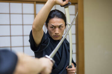 Japanischer Kampfsportler beim Kendo-Training in einem Dojo - Samaurai beim Üben in einer Turnhalle - DMDF05013