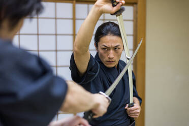 Japanischer Kampfsportler beim Kendo-Training in einem Dojo - Samaurai beim Üben in einer Turnhalle - DMDF05014
