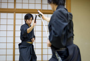 Japanischer Kampfsportler beim Kendo-Training in einem Dojo - Samaurai beim Üben in einer Turnhalle - DMDF05015