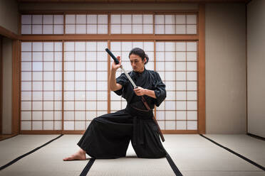 Japanischer Kampfsportler beim Kendo-Training in einem Dojo - Samaurai beim Üben in einer Turnhalle - DMDF05017