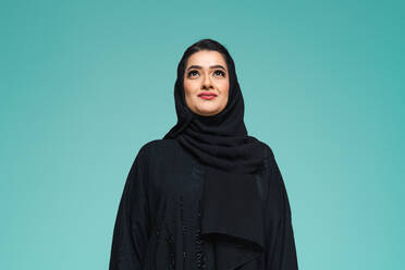 Schöne arabische Frau aus dem Nahen Osten mit traditionellem Abaya-Kleid im Studio - Arabisches muslimisches Frauenporträt in Dubai, Vereinigte Arabische Emirate - DMDF05042