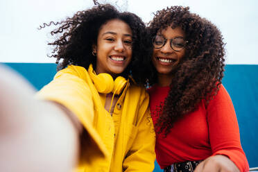 Young happy women taking selfies with the smartphone. Teenagers having fun outdoor after school - DMDF05156