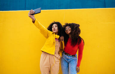 Young happy women taking selfies with the smartphone. Teenagers having fun outdoor after school - DMDF05170