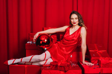 Schöne junge Frau mit rotem Kleid und Geschenke, Weihnachten und festliche Tage Konzepte - DMDF05286