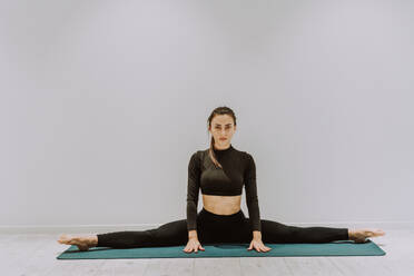 Beautiful young atlethic woman wearing sportswear doing yoga meditation on  the terrace rooftop with sea view and blue sky - Yoga practicer training  outdoors, healthy lifestyle, sport and meditation concept stock photo