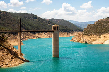 Drone view of Francisco Abellán Reservoir bridge above blue water on sunny day located in La Peza in Spain - ADSF47213