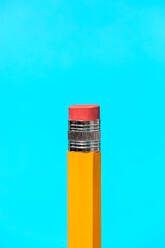 Closeup of yellow pencil with red rubber on blue background representing the concept of education - ADSF47251