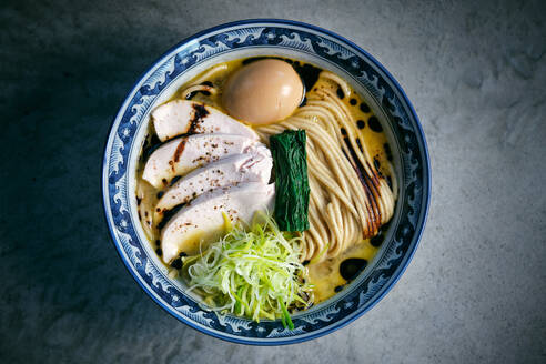 Overhead view of Japanese noodle soup with chicken slices and seaweed in broth with boiled egg for lunch - ADSF47413