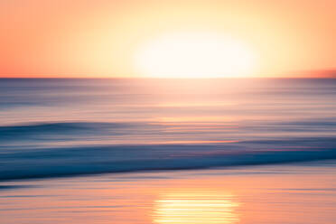 Breathtaking view of vibrant sundown sky over wavy sea in evening - ADSF47609