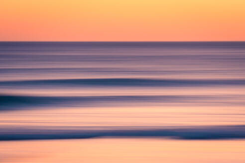 Breathtaking view of vibrant sundown sky over wavy sea in evening - ADSF47610