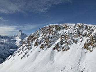 Picturesque view of rocky snowy mountains against blue sky in winter in Zermatt, Switzerland - ADSF47779