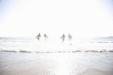 Silhouette of surfers running in the sea - FSIF06551