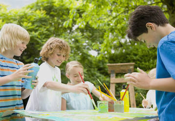 Children painting and smiling in Garden - FSIF06560