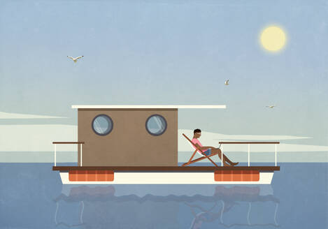 Man relaxing, using laptop on houseboat on sunny summer lake - FSIF06575