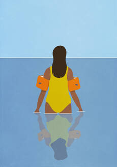 Woman in bathing suit and water wings wading in ocean water - FSIF06595