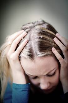 Young Woman Suffering From Depression With Head In Hands - INGF12127