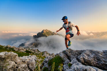Mann Ultramarathonläufer in den Bergen trainiert er bei Sonnenuntergang - INGF12150