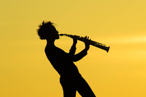 Playing saxophone silhouette on yellow background - INGF12157